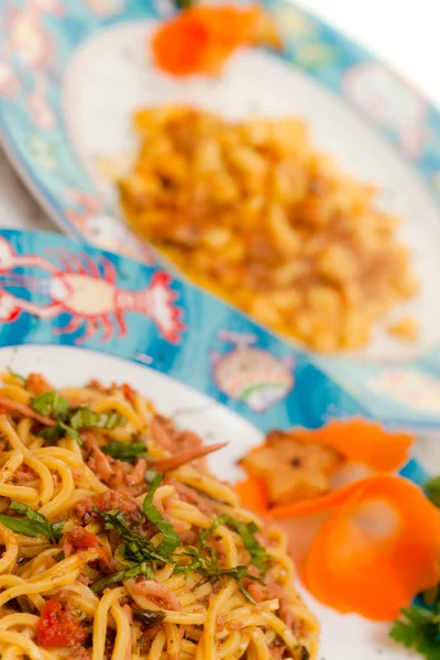 Spaghetti med seafoood med gnocchi i bakrunden — Stockfoto