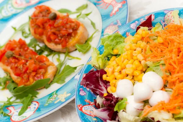 Blanda sallad med tomat bruschetta på bakgrund. — Stockfoto