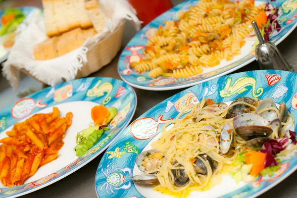 Spaghetti with clams, fusilli, penne and bread on background. — Stock Photo, Image