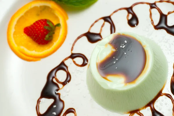 Mint panna cotta on white plate decorated with strawberry and or — Stock Photo, Image