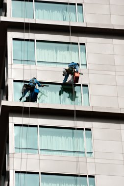 iki adam Windows üzerinde bir yüksek bina temizlik