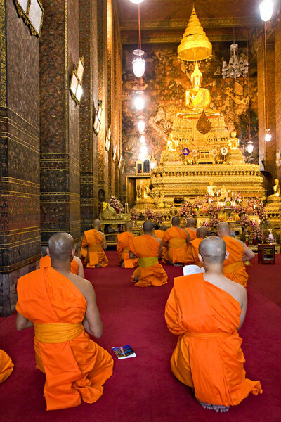 Monks praying at Wat Po, Bangkok, Thailandia.