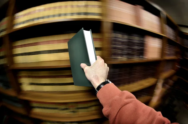 Libro de mano en la biblioteca — Foto de Stock