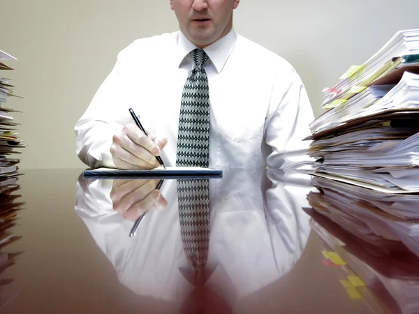 Businessman at Desk with Files Writing — Stock Photo, Image