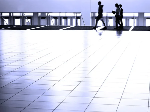 Menschen gehen auf weißem reflektierendem Boden — Stockfoto