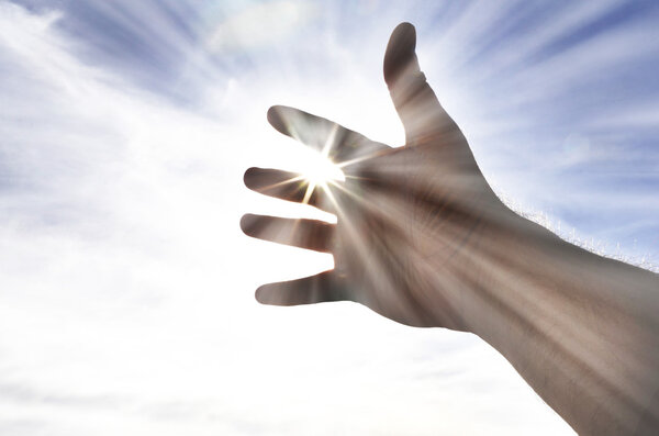 Person's Hand Reaching Towards Heaven Sunlight