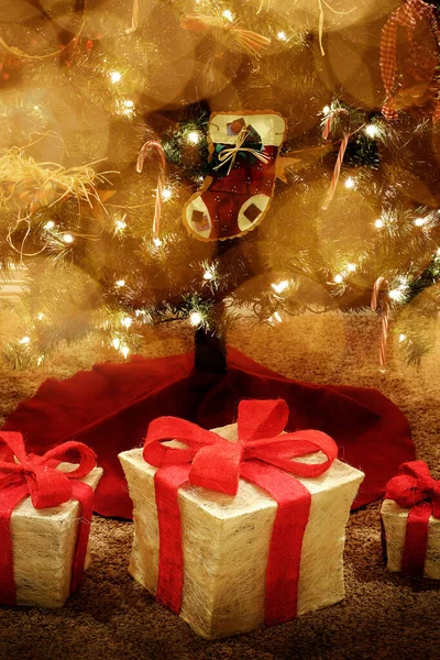 Dárek Pod Jasně Zdobené Vánoční Stromeček Červenou Stuhou Zabalenými Dárky — Stock fotografie