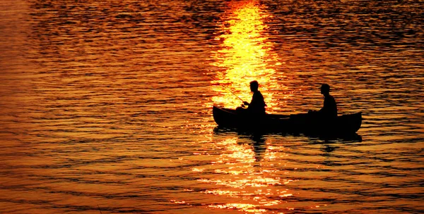 日の出のレクリエーションで湖や川でカヌー釣り2人 — ストック写真