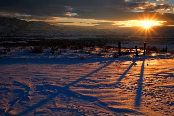 Východ Slunce Nebo Západ Slunce Kůlech Plotu Vrhá Stíny Zasněženou — Stock fotografie