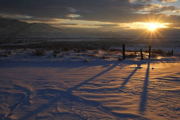 在雪地上投下阴影的挡土墙上的日出或日落阳光 — 图库照片