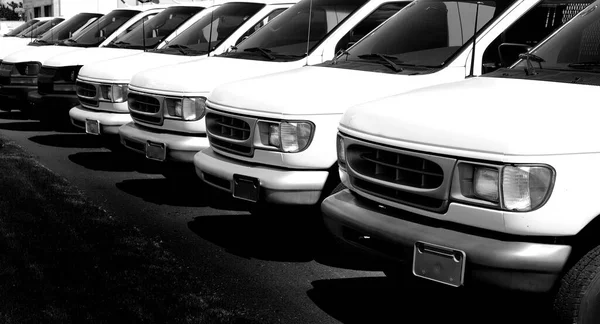 Row of white vans to deliver cargo truck transportation and delivery for sale car lot