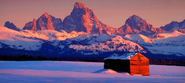 Teton Dağları, kışın Sunset Light Grand Tetons ve tarlada eski bir kulübe.