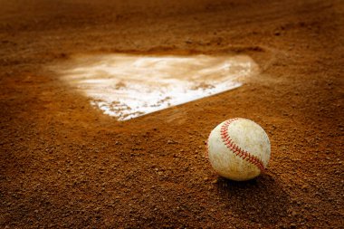 Old leather baseball on dirt field by home plate or a base  clipart