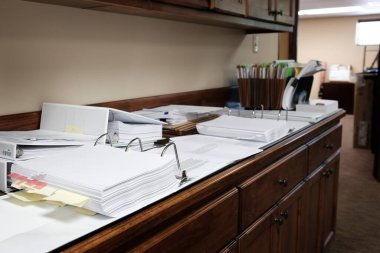Binders on desk or shelves in an office for organizing business documents