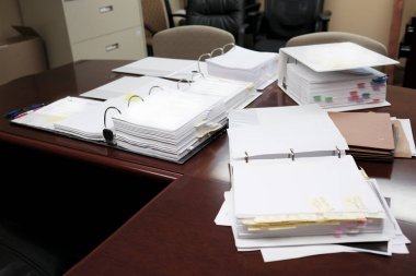 Binders on desk or shelves in an office for organizing business documents