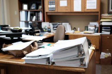 Binders on desk or shelves in an office for organizing business documents