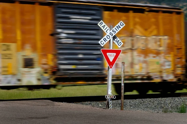 Railroad Crossing Sign Rail Cars Engine Blurred Speeding Transporting Items — стоковое фото