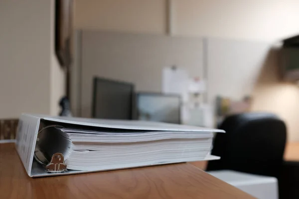 Binders on desk or shelves in an office for organizing business documents