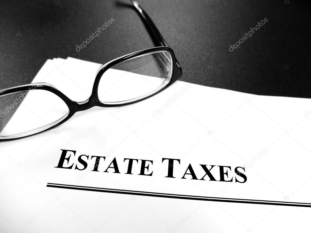 Estate tax taxes documents on desk with glasses for planning