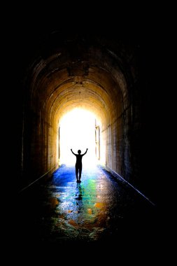 Single individual person at end of tunnel for success and triumph at end of journey