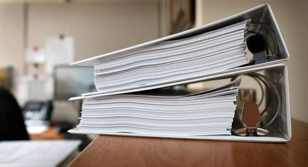 Binders on desk or shelves in an office for organizing business documents
