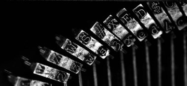 Detail closeup of old typewriter striker keys for writing communication with symbols black and white