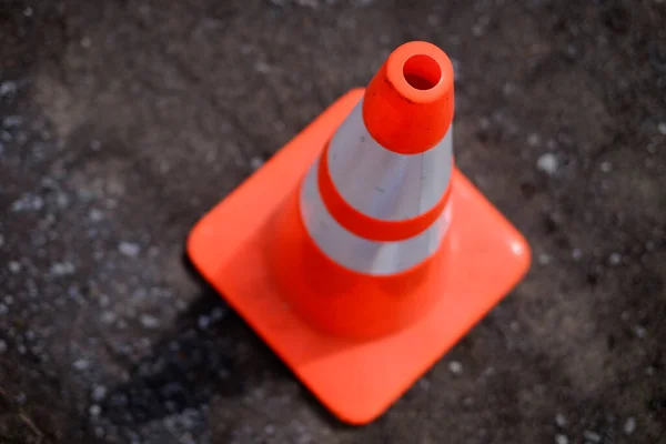 Orange construction cone for safety and warning of danger on gravel road