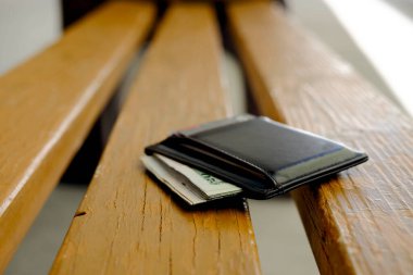 Lost wallet with cash on a bench seat forgotten and abandoned