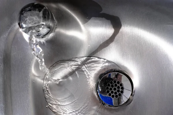 Stahlblech Glänzendes Waschbecken Mit Wasser Das Den Abfluss Hinunterfließt — Stockfoto