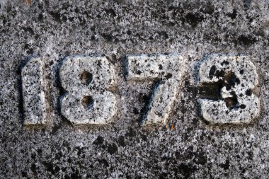 Taş 1873 'te kabaca şekillendirilmiş oyulmuş sayılar.