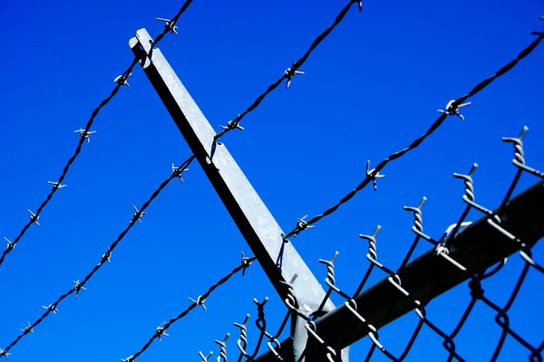 有刺铁丝网围栏 用延伸的金属臂提供安保和安全 — 图库照片