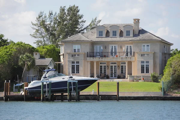 Luxurious waterfront mansion with a boat — Stock Photo, Image