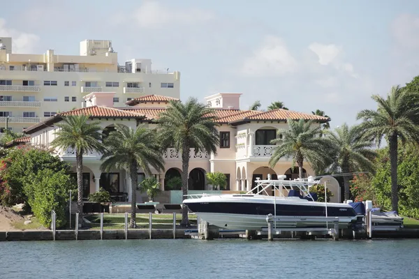 Luxurious waterfront mansion with a boat — Stock Photo, Image