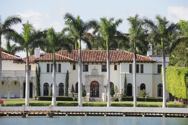 Luxurious waterfront mansion with palm trees — Stock Photo, Image