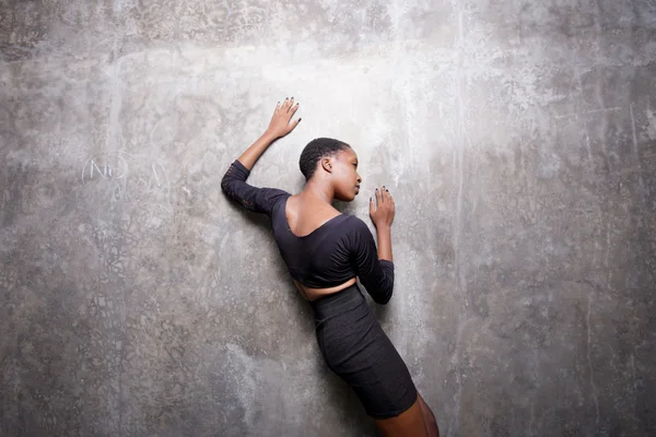 Mujer acostada en una pared de hormigón grueso — Foto de Stock