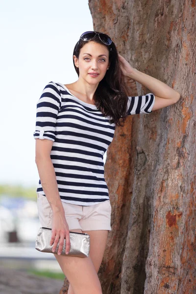 Stock imagen mujer apoyada en un árbol en el parque — Foto de Stock