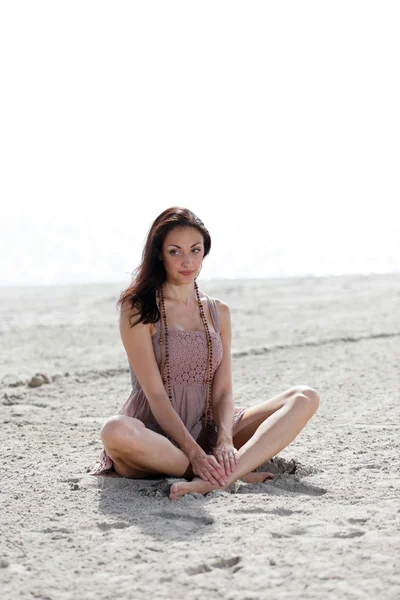 Kadın kumda oturuyor. — Stok fotoğraf