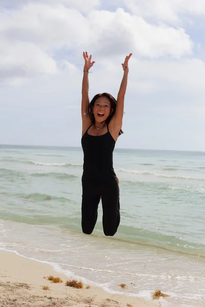 Vrouw springen op het zand stockfoto — Stockfoto