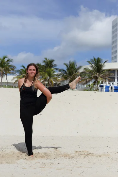 Mulher em uma pose de ioga na praia — Fotografia de Stock