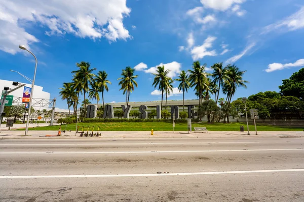 Miami, FL, ABD - 25 Eylül 2021: Bayside imzalı Miami. Bulutlarda ve palmiye ağaçlarında uzun pozlama bulanıklığı