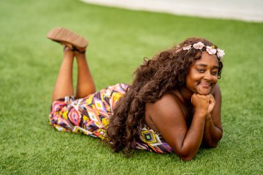 Tropikal bir ortamda renkli bir elbise içinde poz veren çok ırklı güzel bir kadın model.