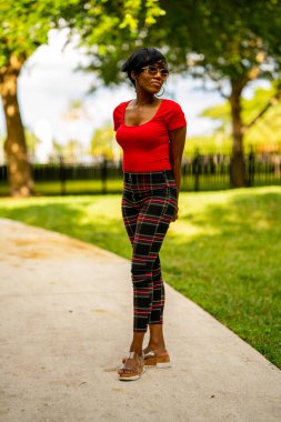 Parkta poz veren güzel bir kadın modelin fotoğrafı.