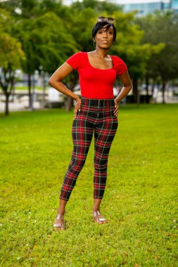 Parkta poz veren güzel bir kadın modelin fotoğrafı.