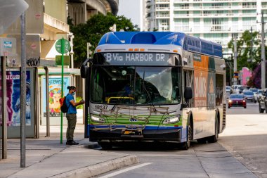 Miami, FL, ABD - 30 Ekim 2021: Yüz maskesi takılı bir adamın metro otobüsüne girdiği fotoğraf