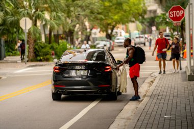 Miami, FL, ABD - 30 Ekim 2021: Uygulamalar sürekli maske takmayı gerektirirken, genç bir adamın maskesiz bir şekilde fotoğraf çekmesi