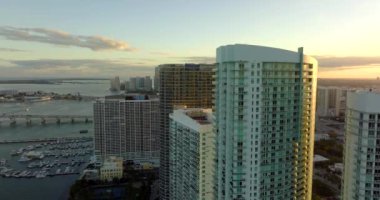 Günbatımında yüksek binaların etrafında uçmak 5k hava videosu