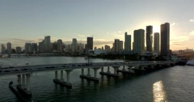 Macarthur Causeway 'de günbatımında Miami' de hava trafiği var.