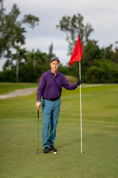 高尔夫球手在高尔夫球场上举着旗杆 — 图库照片