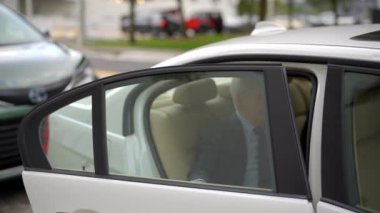 İş adamı araç paylaşımından çıkıyor. Uber lyft araba ve kapıyı kapatıyor.