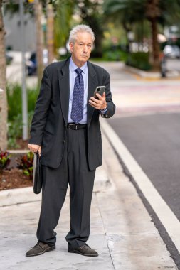 İş adamı, telefon uygulamasındaki Uber Lyft aracını ve takip cihazını bekliyor.